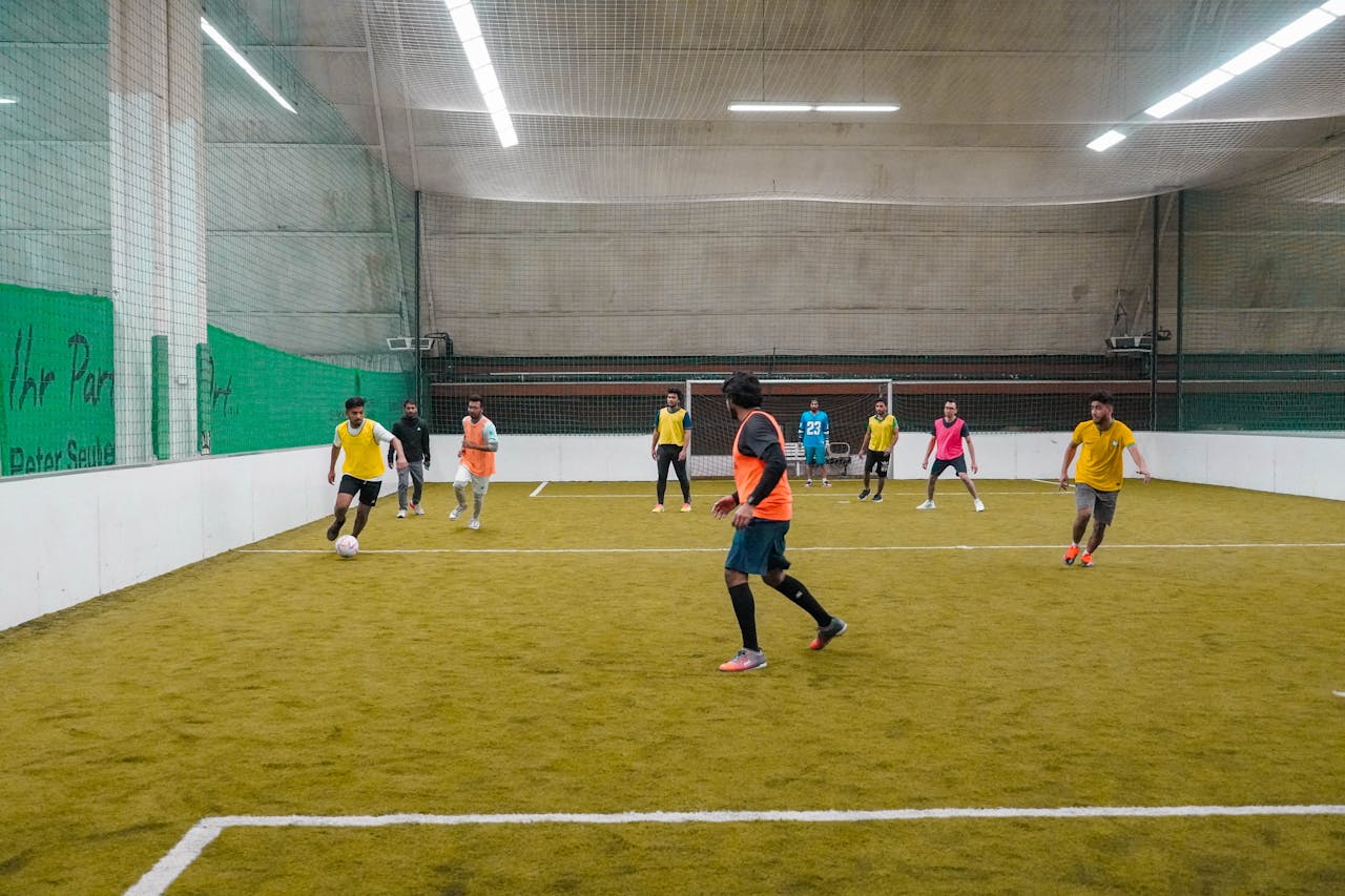 services-03 A lively indoor soccer game with diverse players actively engaging in the sport.