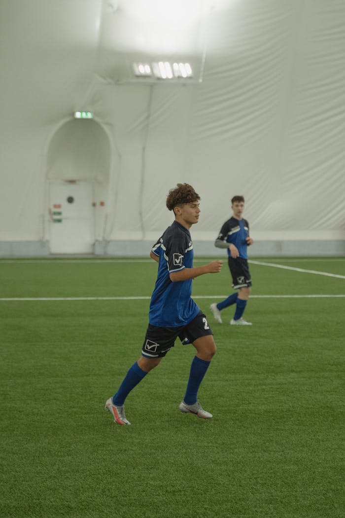 services-01 Young soccer players actively engaged in a game on an indoor field.