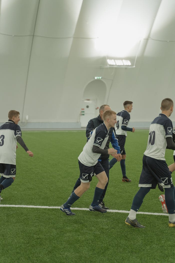 services-02 Young soccer team practicing indoors on artificial field, showcasing teamwork and athleticism.